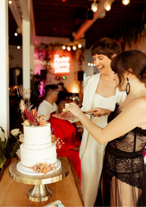LGBTQ couple cutting their wedding cake during an intimate reception at FruitCraft.